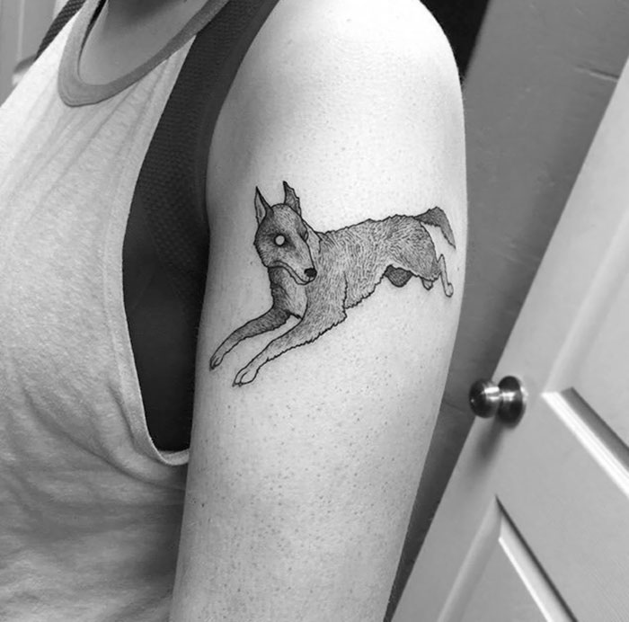 Arm tattoo featuring a detailed jumping dog design, showcasing one of the best dog tattoo ideas.