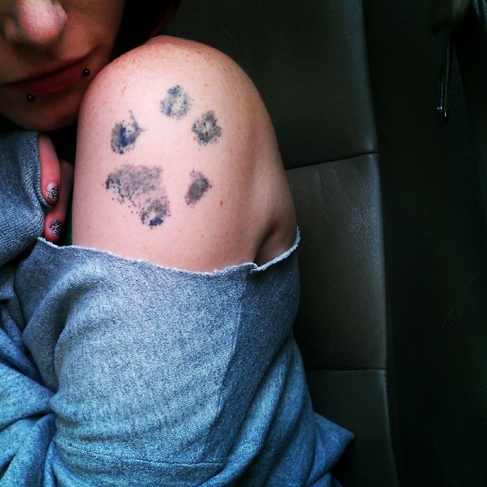 Dog paw tattoo on a person's shoulder, showcasing one of the best dog tattoo ideas.