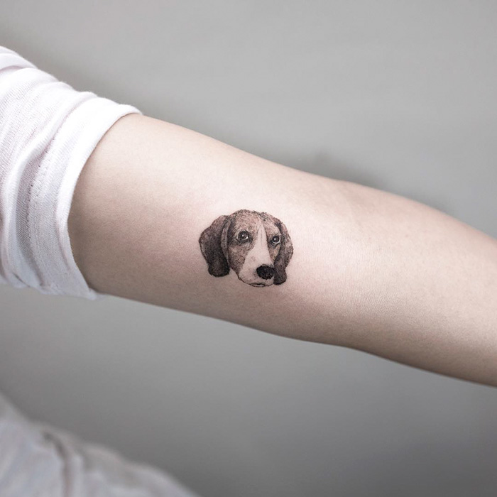 Arm tattoo featuring a detailed dog portrait, showcasing one of the best dog tattoo ideas.