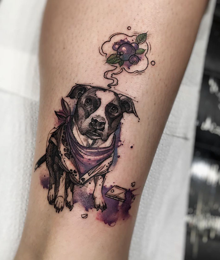 Dog tattoo with a colorful design, featuring a dog thinking about a flower and berry.