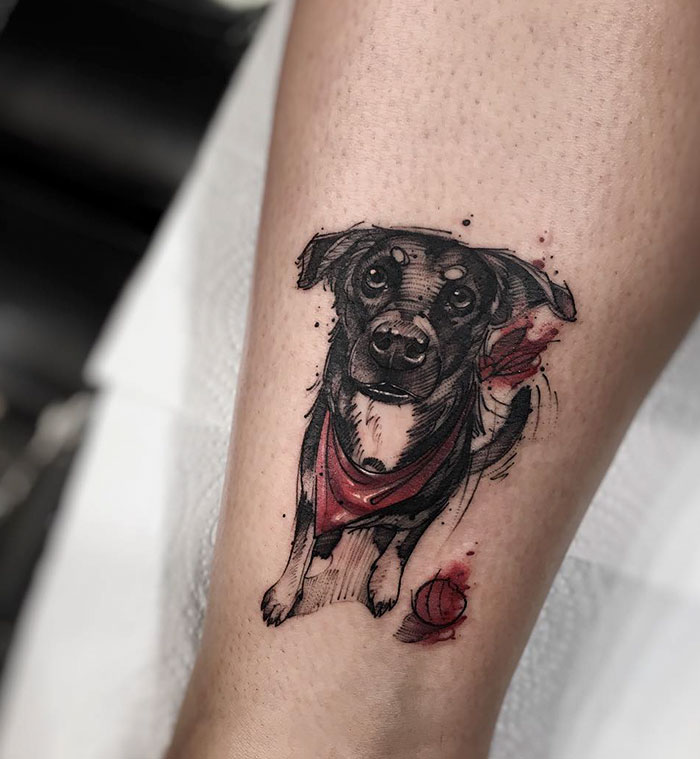 Dog tattoo featuring a playful pup with a red bandana, showcasing detailed artistry on the skin.