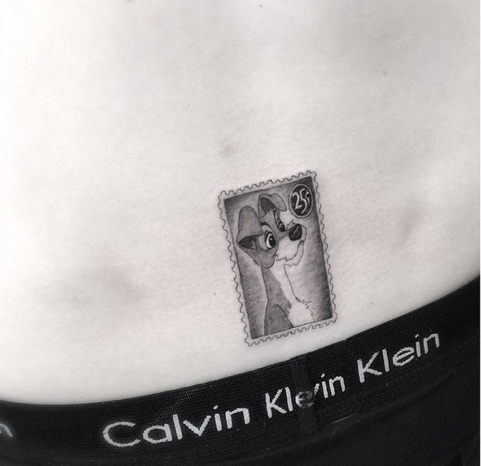Small dog tattoo designed as a vintage stamp on a person's waist, wearing Calvin Klein underwear.