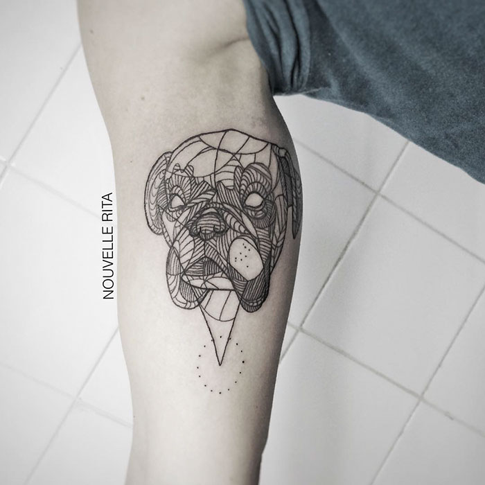 Geometric dog tattoo design on arm showcasing intricate linework.