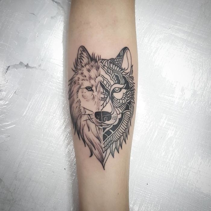 Wolf-themed dog tattoo on a forearm, showcasing a blend of realistic and geometric styles.