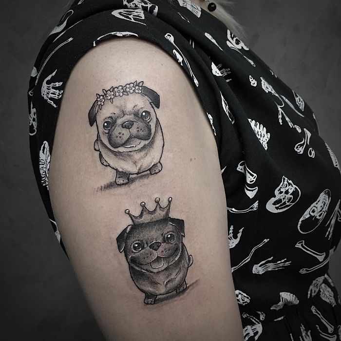 Two cute dog tattoos on an arm, one with a flower crown and another with a royal crown.