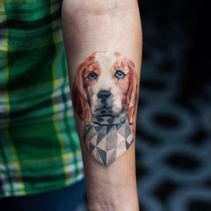 Geometric dog tattoo on forearm, showcasing a creative and colorful design.