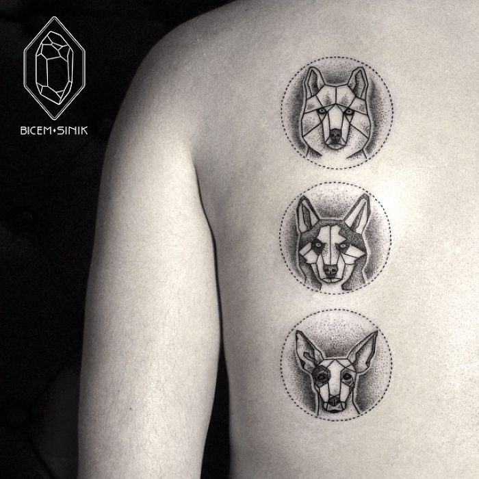Geometric dog tattoos in black ink, featuring three distinct dog faces on the side of a person's body.