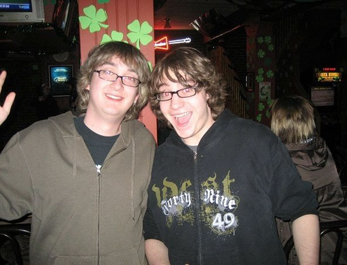 Two doppelgangers hugging at the bar 