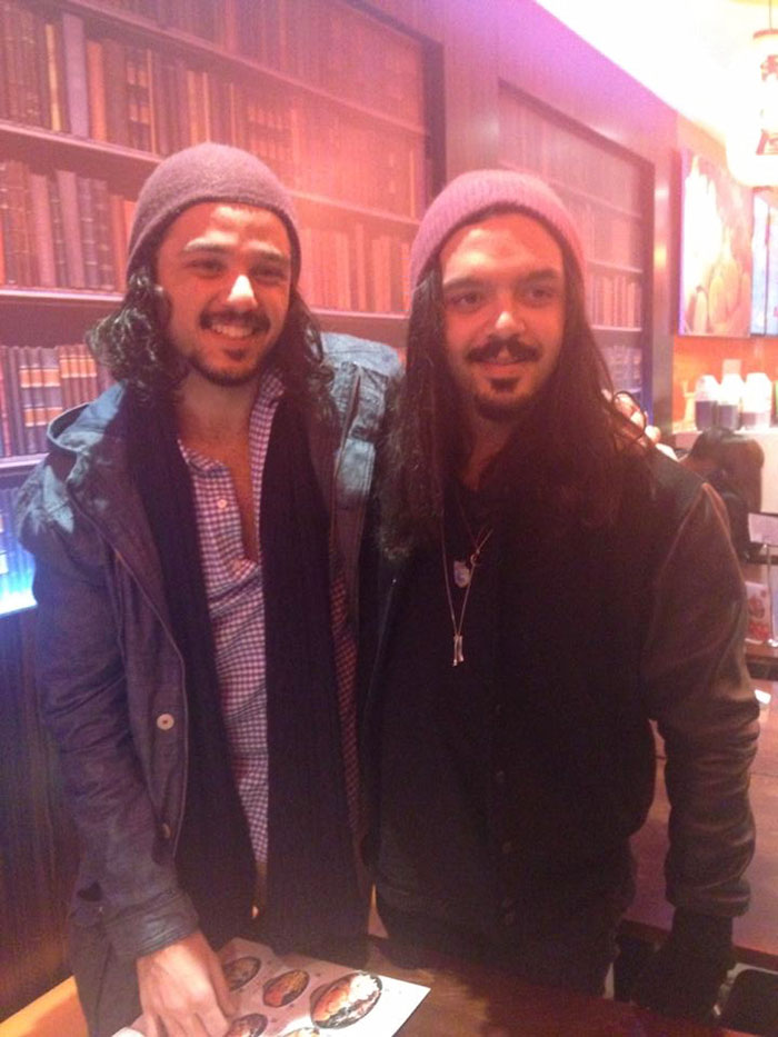 Two doppelgangers hugging in a library 