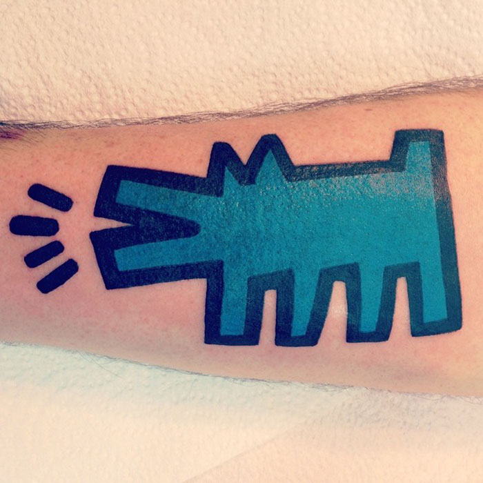 Classical art-inspired tattoo featuring a stylized blue dog on an arm.