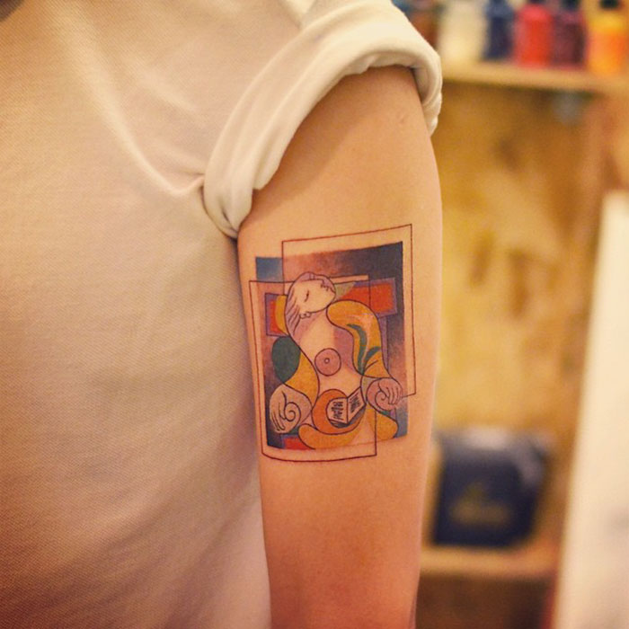 Classical art-inspired tattoo on an arm, featuring abstract geometric shapes and vibrant colors.