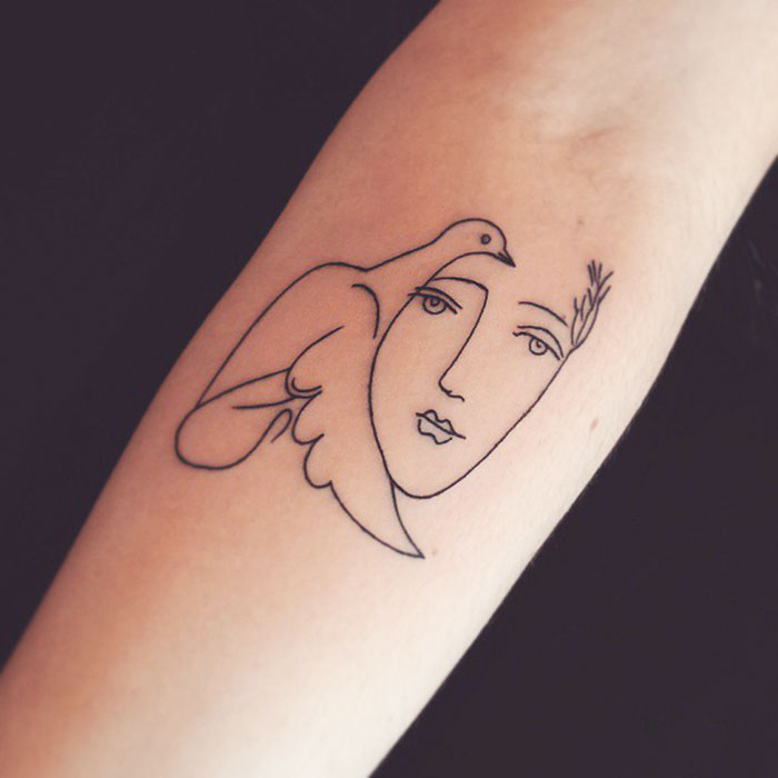 A minimalist tattoo on an arm, featuring a line art face blended with a bird, inspired by classical art.