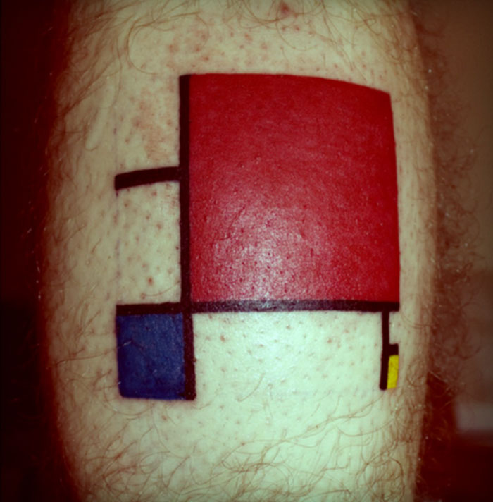 Tattoo inspired by classical art with red, blue, and yellow squares on skin.