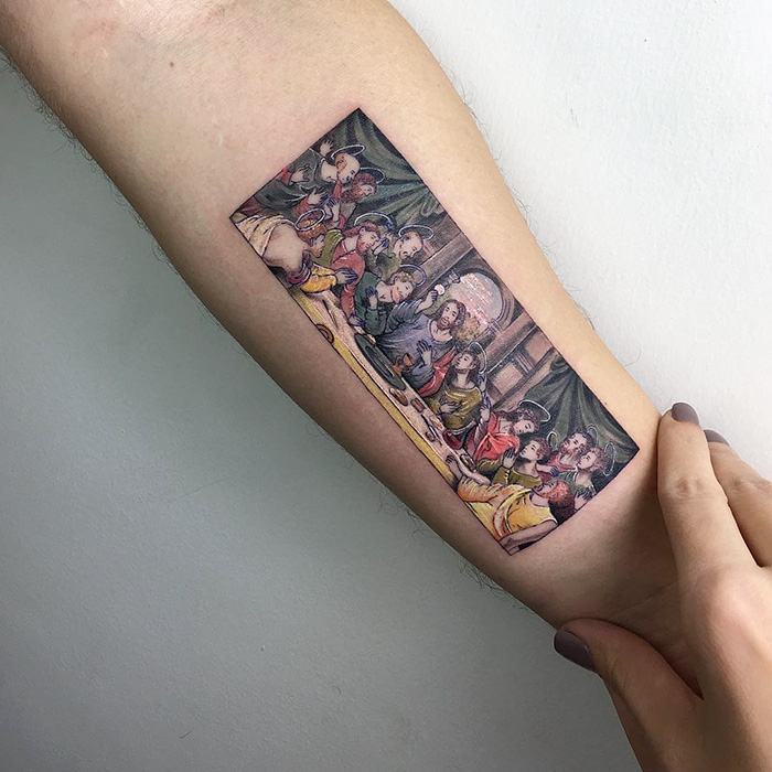A classical art-inspired tattoo on an arm, depicting a detailed and colorful scene.