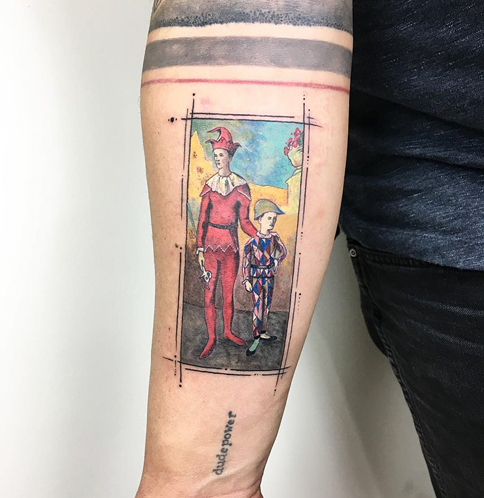 Classical art-inspired tattoo of jesters on forearm, blending vibrant colors and intricate details.