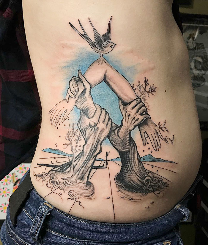 Classical art-inspired tattoo featuring surreal hands and a bird on a person's side.