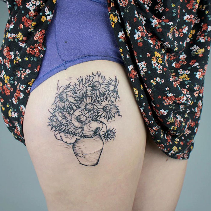 Tattoo of classical art featuring a vase of sunflowers on a thigh, inspired by classical designs and floral patterns.