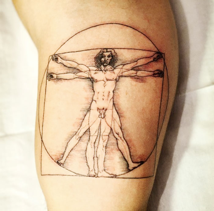 Classical art-inspired tattoo depicting Leonardo da Vinci's Vitruvian Man on a person's arm.