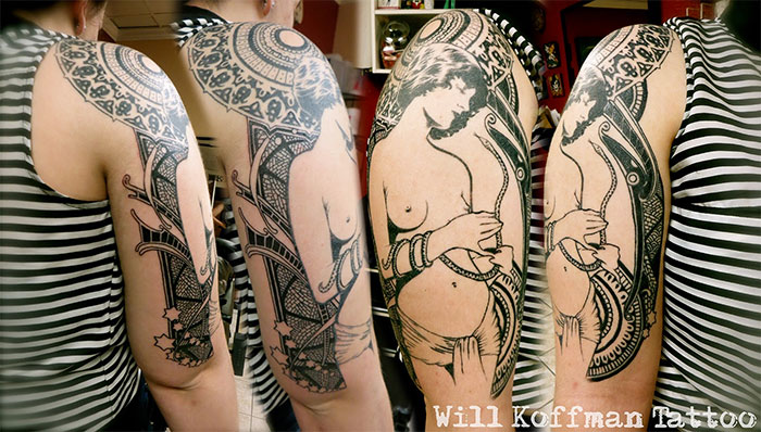 Classical art-inspired tattoo featuring intricate designs and a n**e figure on an arm.