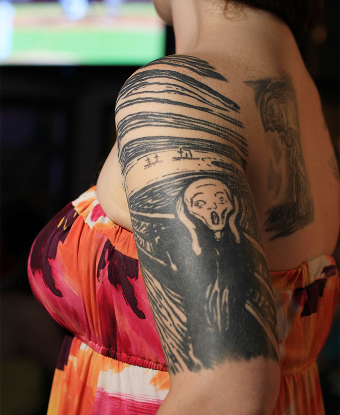 Arm tattoo inspired by classical art, featuring a detailed rendition of "The Scream" in black ink on colorful background.
