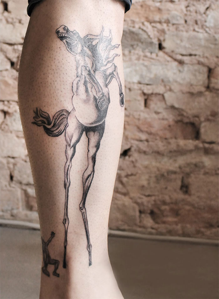 Classical art-inspired tattoo of a surreal horse on a person's calf.