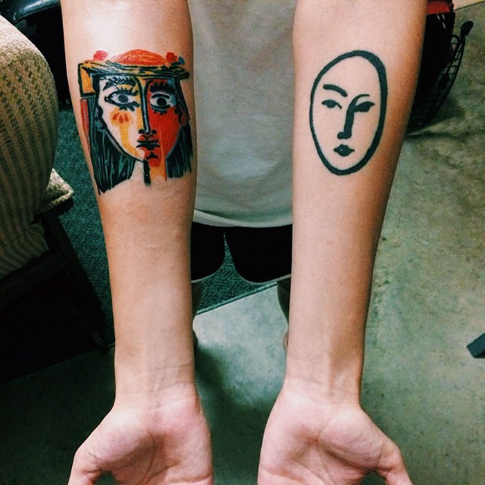 Two forearm tattoos inspired by classical art, one colorful abstract face, and one minimalist line face.