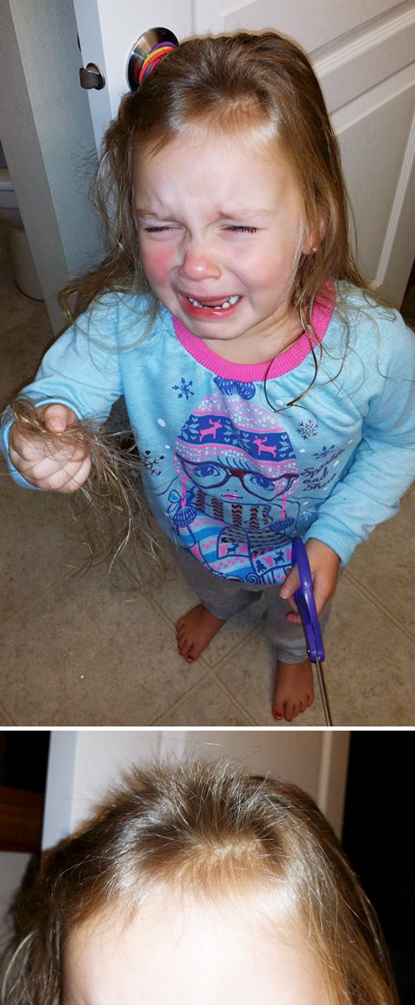 Child holding scissors and crying after cutting their own hair, wearing a blue winter-themed shirt.