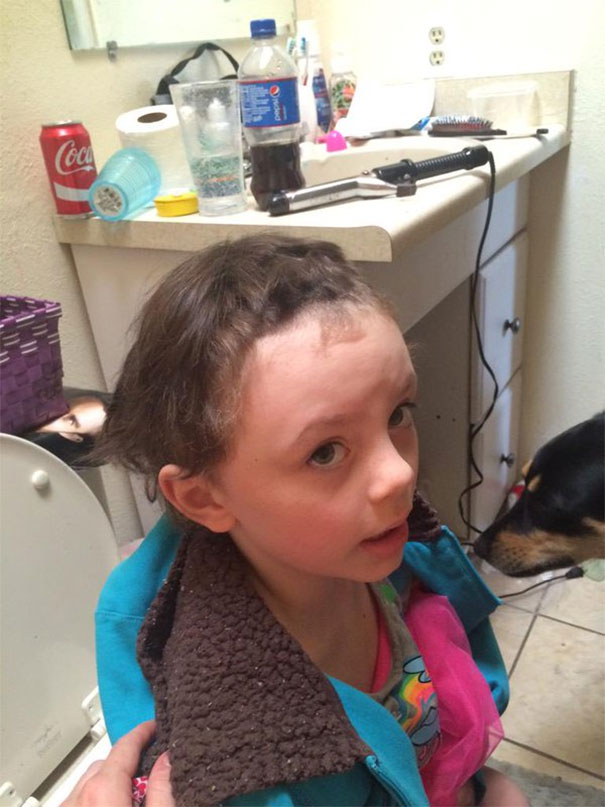 Young child with uneven haircut after deciding to cut own hair, surrounded by bathroom items.