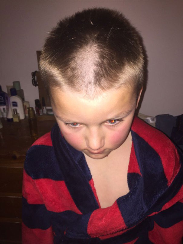 Child with uneven haircut, looking down, wearing a red and blue robe, embodying a self-inflicted hairstyle mishap.