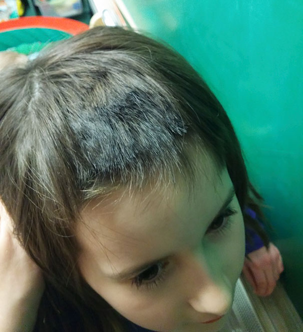Child with a self-done haircut, uneven bangs, and a regretful expression, showing kids cutting their own hair.