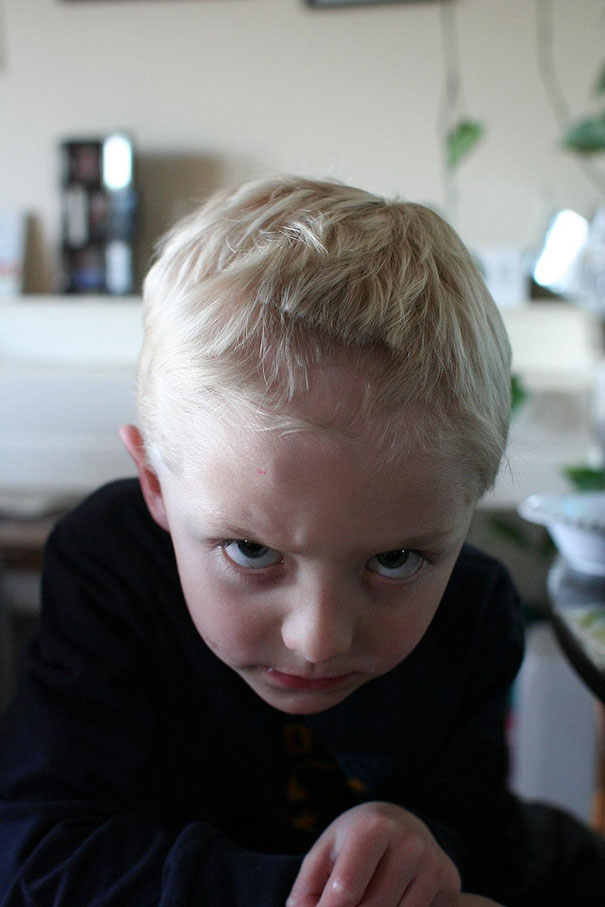 Child with a self-cut hairstyle looking regretful, illustrating kids’ hair decisions gone wrong.