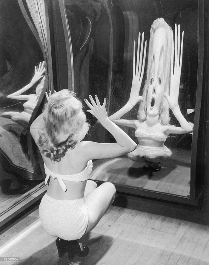 A Woman In A Toweling Bikini Poses In A Funfair Hall Of Mirrors, Circa 1935