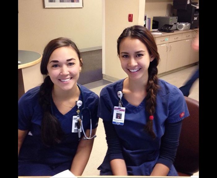 Two doppelgangers in a nurse outfits sitting on chairs in a hospital 