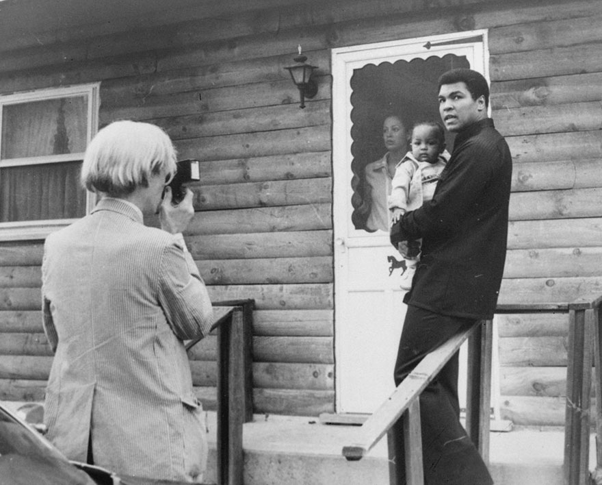 Pop Artist Andy Warhol, Left, Is Shown Photographing Muhammad Ali, His Infant Daughter, Hanna, And Wife, Veronica, Thursday, August 18, 1977, At Ali's Training Camp In Deer Lake, Pa