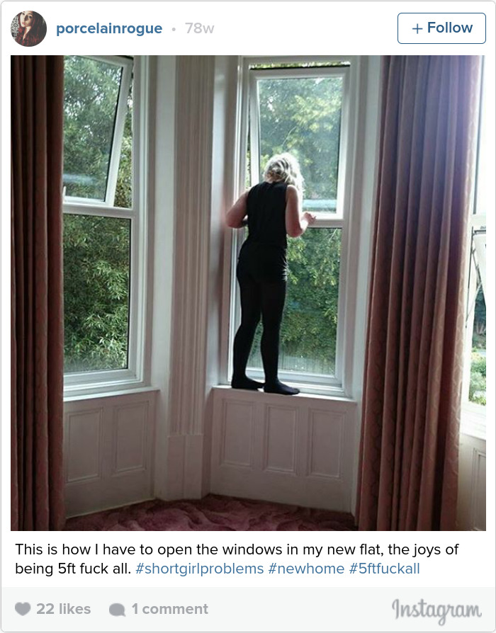 Person stands on a windowsill, illustrating short people problems with reaching high windows in a new home.
