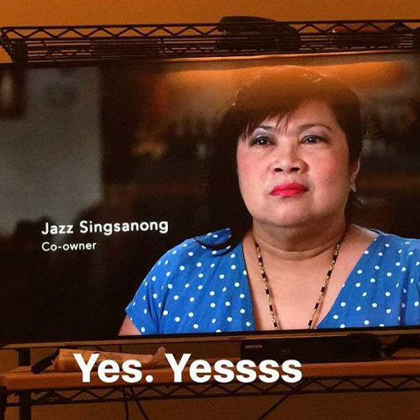TV screen displaying a co-owner with a humorous name, Jazz Singsanong, wearing a blue polka dot shirt.