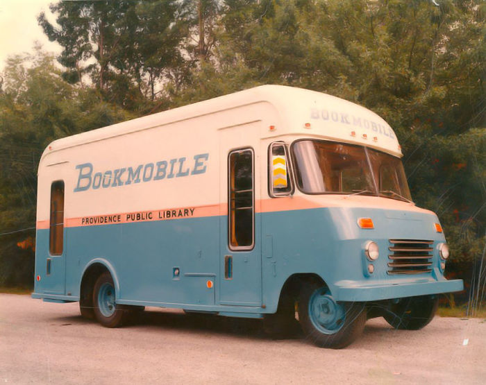 Vintage bookmobile from Providence Public Library parked outdoors with trees in the background, showcasing libraries-on-wheels concept.
