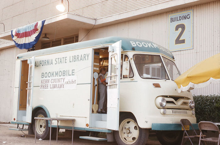 Vintage California State Library bookmobile parked outside a building, showcasing rare libraries-on-wheels from mid-20th century.