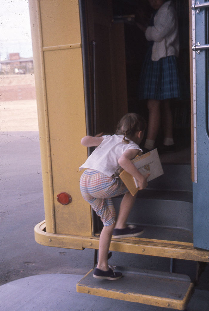 Young girl carrying books and stepping into a bookmobile, illustrating libraries on wheels before digital bookstores.