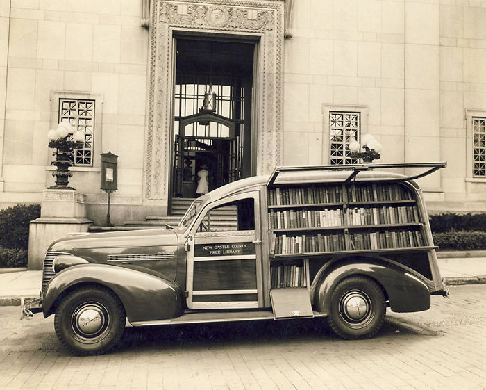 Vintage bookmobile from New Castle County Free Library parked outside a building, showcasing libraries-on-wheels concept.