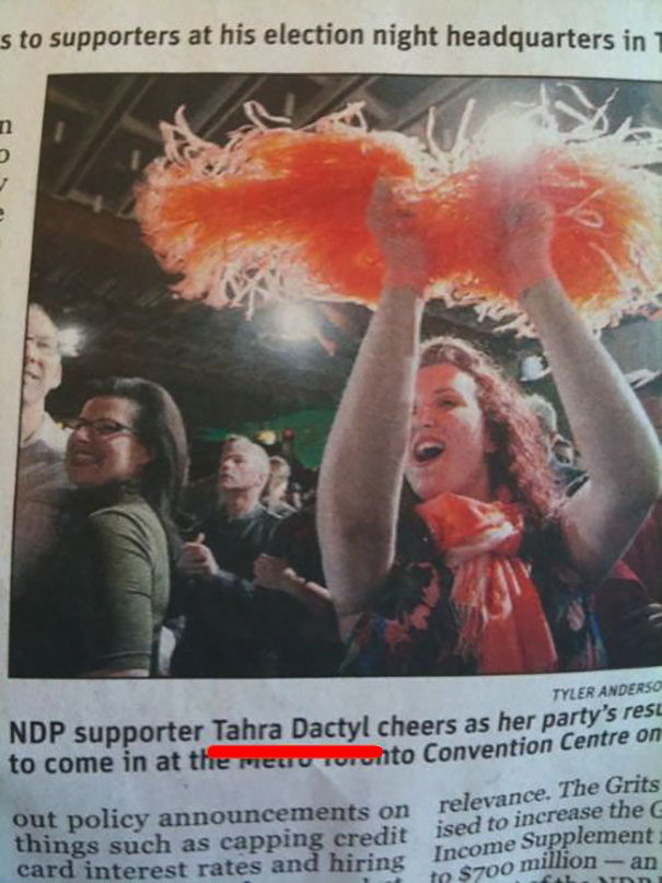 Cheerful supporter with a funny name celebrates enthusiastically with orange pom-poms.