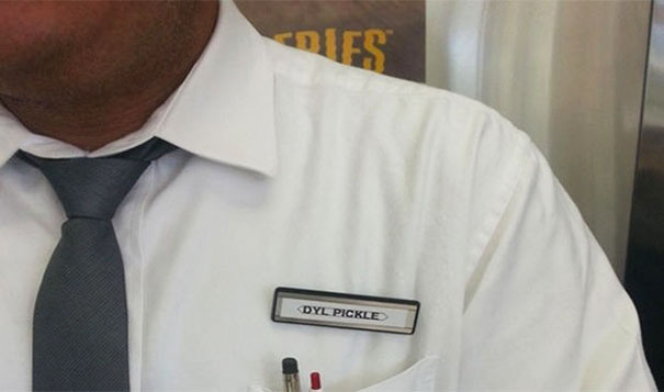 Person wearing a white shirt and tie with a name tag displaying a funny name.