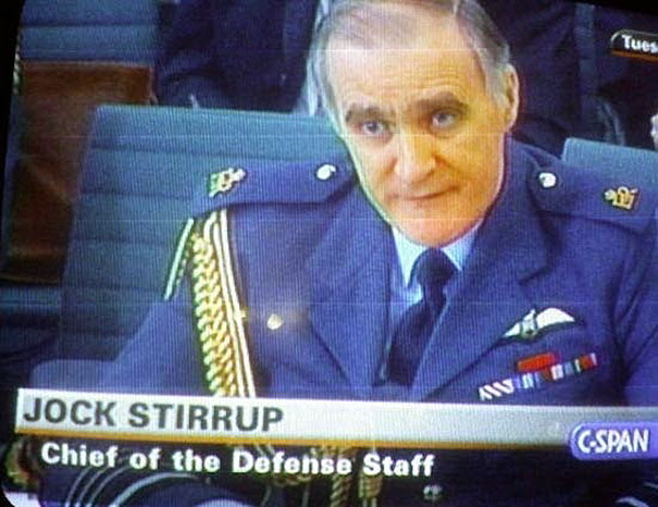Man in military uniform with "funny names" label, seated at a desk.