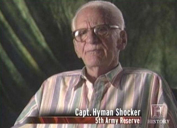 Man in glasses and striped shirt with funny name caption, from a documentary series.