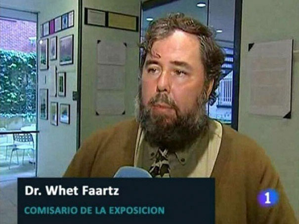 Man with a humorous name, Dr. Whet Faartz, being interviewed in an exhibition setting.