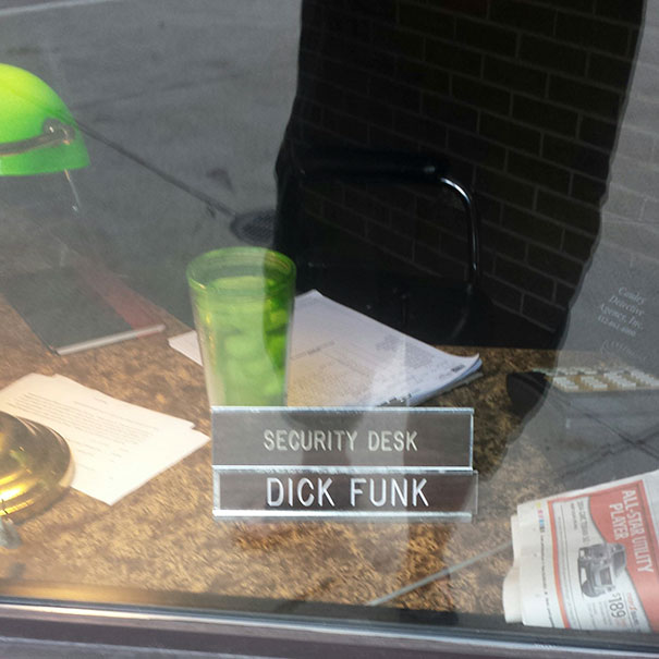 Security desk with a nameplate reading "D**k Funk," featuring funny names in an office setting.