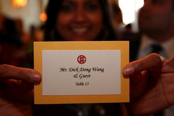Person holding a place card for Mr. D**k Dong W**g, showcasing funny names at a formal event.