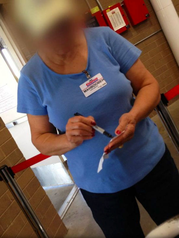 Person in a store wearing a name tag with a funny name, writing on a notepad.