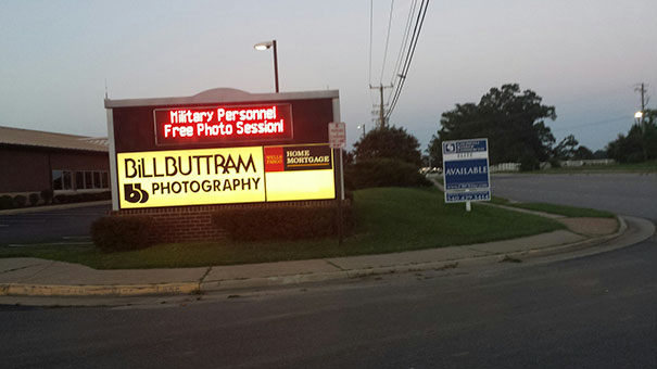 Sign for Billbuttram Photography offers free photo session for military personnel, included in funny names list.