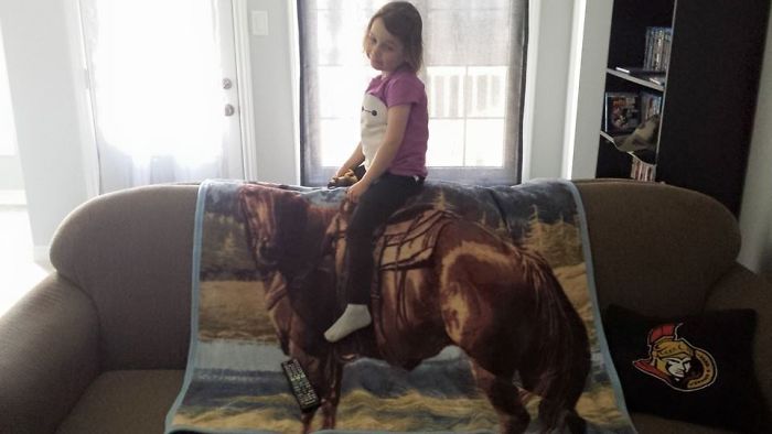 Child sitting on couch horse blanket, dad joke creativity at its best.